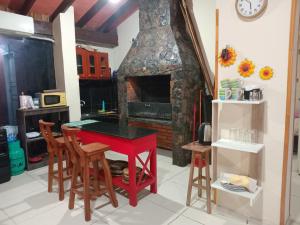 a kitchen with a red table and a fireplace at Departamento Luque in Luque +4 photos