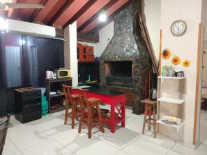 a kitchen with a red table and a fireplace at Departamento Luque in Luque