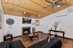 a living room with a ceiling fan and a fireplace at Stylish Elysian Big Bear Cabin w Enclosed backyard in Big Bear City