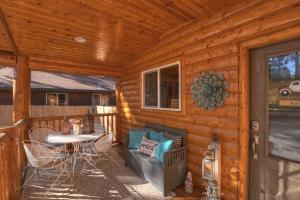 a cabin with a patio with a table and chairs at Stylish Elysian Big Bear Cabin w Enclosed backyard in Big Bear City