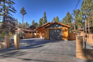 a log home with a garage and a driveway at Stylish Elysian Big Bear Cabin w Enclosed backyard in Big Bear City +23 photos