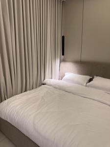 a bedroom with two beds with white sheets and curtains at استوديو حي حطين in Riyadh