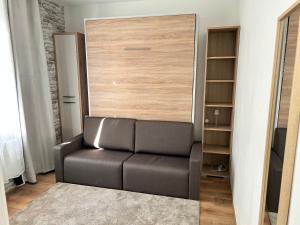 a leather chair in a room with a closet at Cocon romantique Jardin de la princesse idéal couple Calme & nature Vosges in Senones