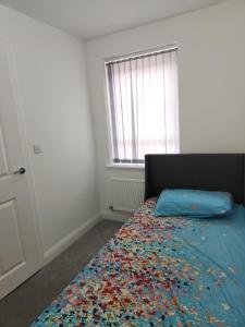 a bedroom with a bed with a colorful blanket at Edinburgh Road Nuneaton in Moffat