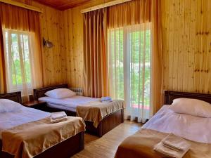 a bedroom with two beds and two windows at Кирч Горис in Goris