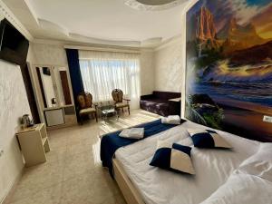 a bedroom with a large bed with a painting on the wall at Кирч Горис in Goris