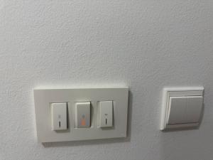 a white light switch on a white wall at Rab Studio first floor 32m2 in Kampor