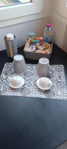 a table with two cups and plates and a tray of food at Modena Private Room in Modena +9 photos