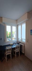 a room with a table and two chairs and windows at Modena Private Room in Modena