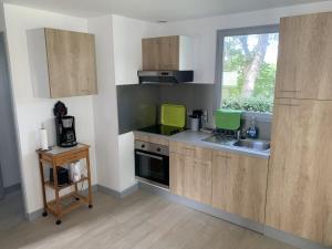 a kitchen with wooden cabinets and a sink and a window at Chalet confortable à Berck-sur-Mer in Berck-sur-Mer