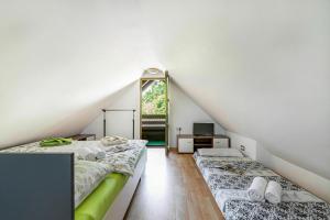 a attic bedroom with two beds and a mirror at Ladybug House Nature Retreat w/ Jacuzzi - Happy Rentals in Fokovci +17 photos