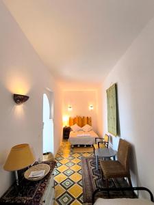 a hotel room with a bed and a table and chairs at Riad Louisa in Chefchaouen