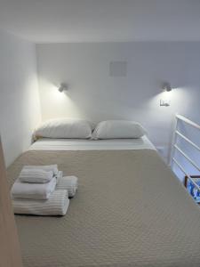a bed with three towels sitting on it at Casetta Velia in Gaeta