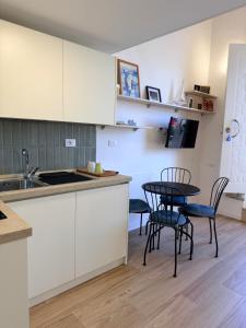 a kitchen with white cabinets and a table and chairs at Casetta Velia in Gaeta