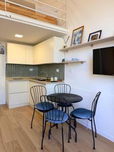 a kitchen with a table and chairs and a tv at Casetta Velia in Gaeta