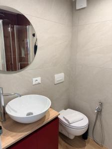 a bathroom with a sink and a toilet and a mirror at Casetta Velia in Gaeta