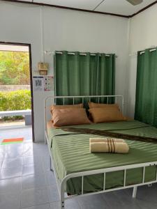 a bedroom with a bed with green curtains at Pineapple Resort Sam roi yot in Sathani Sam Roi Yot