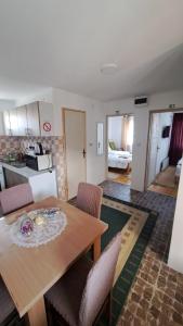 a kitchen and living room with a wooden table and chairs at Kod mosta in Pirot