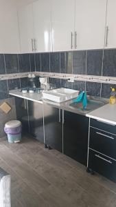 a kitchen with a white counter and a sink at LUX Apartman Sarajevo Centar in Sarajevo