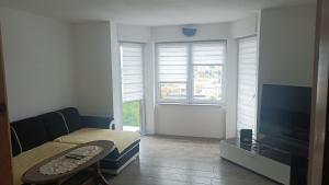 a living room with a tv and a couch and a table at LUX Apartman Sarajevo Centar in Sarajevo