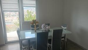 a dining room with a table and chairs and a window at LUX Apartman Sarajevo Centar in Sarajevo +21 photos