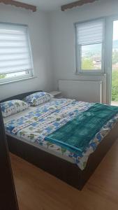 a bed with a quilt on it in a bedroom at LUX Apartman Sarajevo Centar in Sarajevo