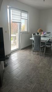 a living room with a table and chairs and a window at LUX Apartman Sarajevo Centar in Sarajevo