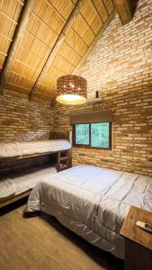 a bedroom with a large bed in a brick wall at Sítio Mello in Igrejinha +50 photos