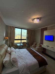 a hotel room with a large bed and a large window at Royal Family Hotel in ‘Aţţān