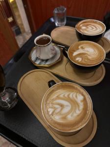 three cups of coffee sitting on a table at Royal Family Hotel in ‘Aţţān