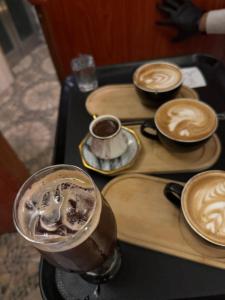 a tray with three cups of coffee on a table at Royal Family Hotel in ‘Aţţān +4 photos