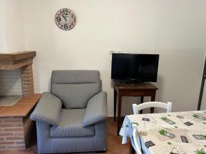 a living room with a chair and a television at Residenze Ponte in Ponte