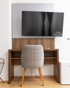 a chair sitting in front of a tv at Kulla e Sahatit - Boutique Hotel in Old Bazaar in Gjakove
