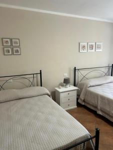 a bedroom with two beds and a dresser with a night stand at Residenze Ponte in Ponte
