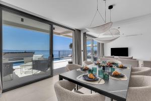 a dining room with a table and chairs with a view of the ocean at Villa Reina in Makarska