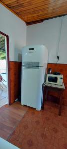 a small kitchen with a refrigerator and a microwave at Contos de Alice in Tiradentes