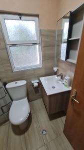 a bathroom with a toilet and a sink and a window at Velipoja Home in Velipojë +16 photos