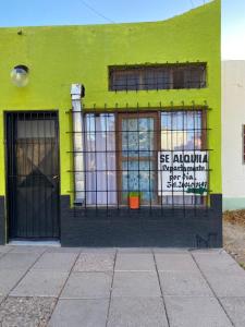 a green building with a gate in front of it at Buen Descanso in Malargüe