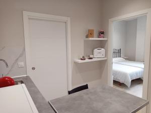 a small white room with a bed and a mirror at D'Canteira in Redondela +3 photos