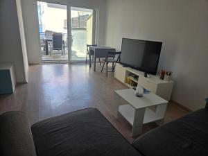 a living room with a couch and a tv and a table at Take it slow in Postira