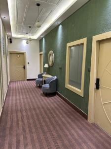 a hallway with two chairs and a table in a room at Divine Hotel in Karnal
