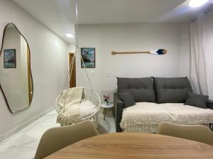 a living room with a couch and a swing at Atlântico 33 Guilhermina in Praia Grande +33 photos