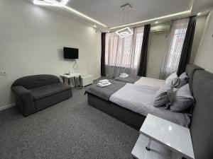 a bedroom with a large bed and a chair at DavidL Hotel Tbilisi in Tbilisi City