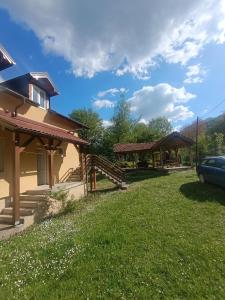 a yard next to a house with a car parked at Anika apartmani in Tjentište