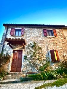 an old stone house with a door and windows at La Gazza Ladra House in Pieve di Carpegna