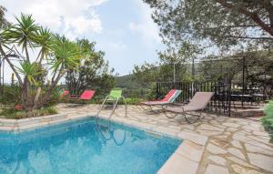 a swimming pool with two chairs and a table at Awesome Home In Rigarda in Rigarda +23 photos