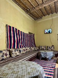 a living room with a couch and a tv at Gite d étape Khettara Oasis in Er Rachidia