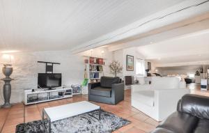 a living room with a couch and a tv at Awesome Home In Rigarda in Rigarda