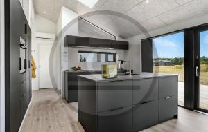 a kitchen with black and white counters and a large window at Awesome Home In Jerup With Sauna in Jerup
