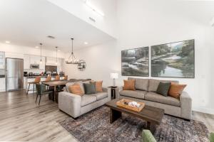 a living room with two couches and a table at Spectacular Penthouse With Amazing Views, Indoor Pool and Hot tub in Canmore